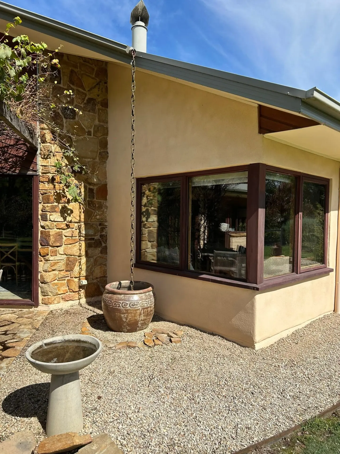 Rendered home courtyard with rain chain and ceramic pot